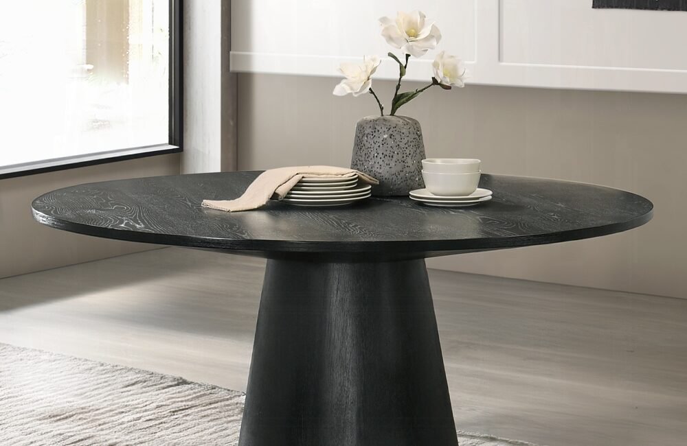 Froja round black dining table with pedestal base in modern Scandinavian style.