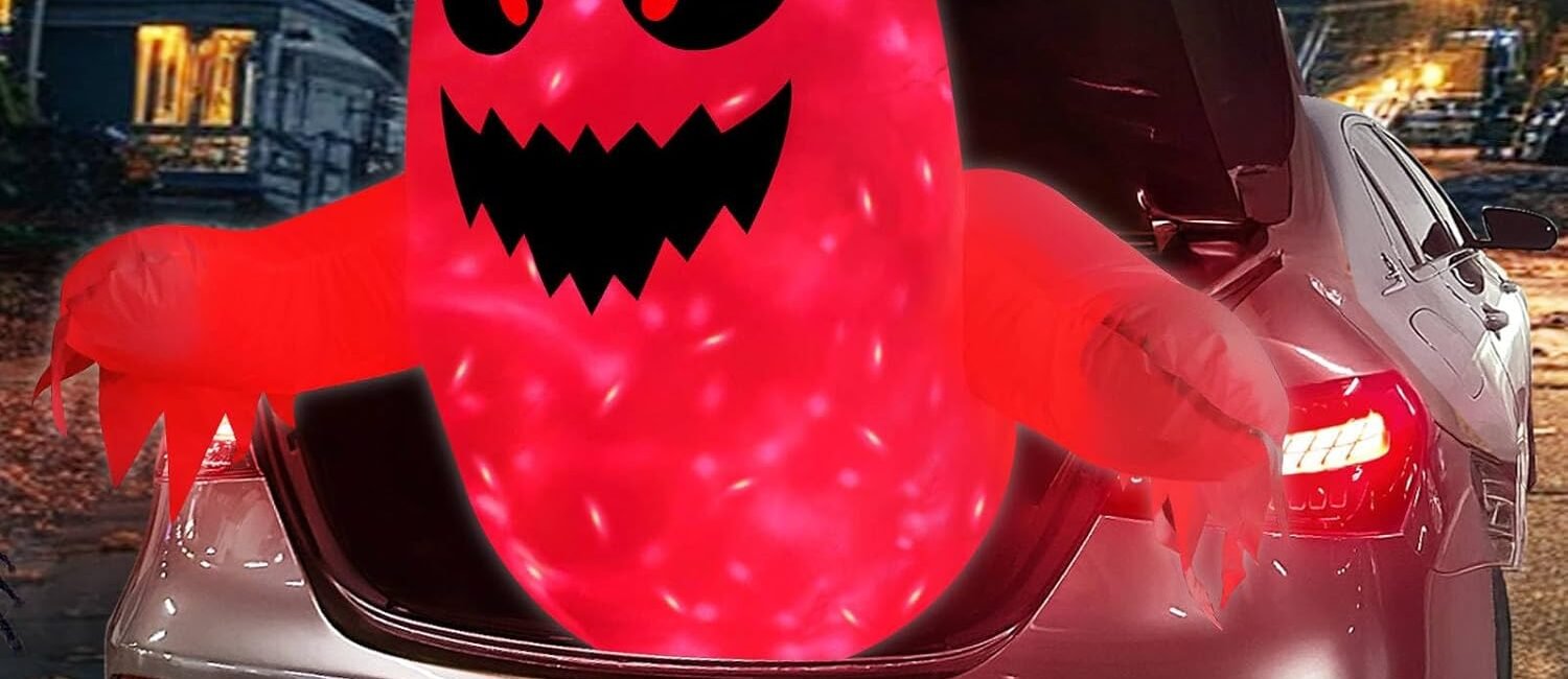 3.5-foot red inflatable Halloween ghost glowing with LED lights emerging from car trunk at night.