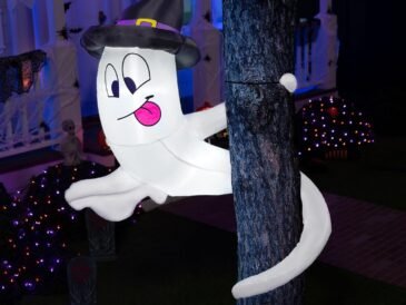 5-foot inflatable Halloween ghost with witch hat and LED lights wrapped around a tree