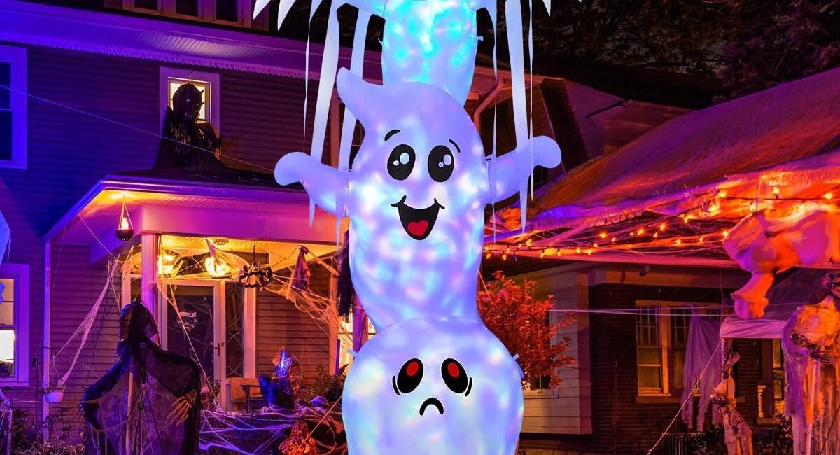 9.8-foot tall inflatable Halloween ghost decoration with built-in LED lights and pumpkin base, glowing at night in a decorated yard