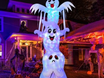 9.8-foot tall inflatable Halloween ghost decoration with built-in LED lights and pumpkin base, glowing at night in a decorated yard