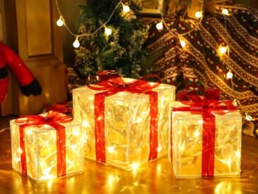 Set of three lighted Christmas gift boxes with red bows and warm white LED glow under a holiday tree.