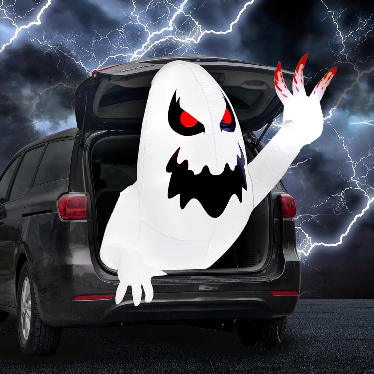 White inflatable Halloween ghost glowing with LED lights, emerging from car trunk with red eyes.