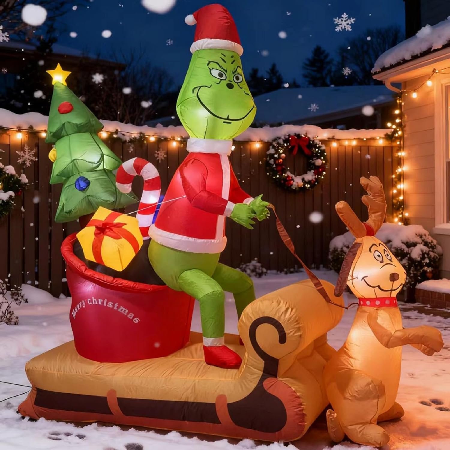 7-foot Green Monster Christmas inflatable featuring the Grinch, Dog Max, and reindeer Fred on a sleigh with built-in LED lights, perfect for outdoor yard decoration