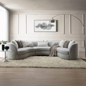 Curved gray boucle sectional sofa with feather-filled pillows in a modern neutral living room setting.