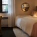 Glam-styled dorm room with faux fur throw, scalloped mirror, and metallic accents