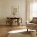 First apartment living space with one accent chair, small dining table, and closed storage dresser