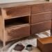 Vintage wood dresser mid-refinishing with sandpaper and stain visible