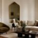 Modern living room with one vintage accent chair and antique brass mirror mixed into contemporary furniture