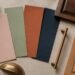 Muted vintage-inspired paint swatches arranged with wood furniture samples and brass hardware